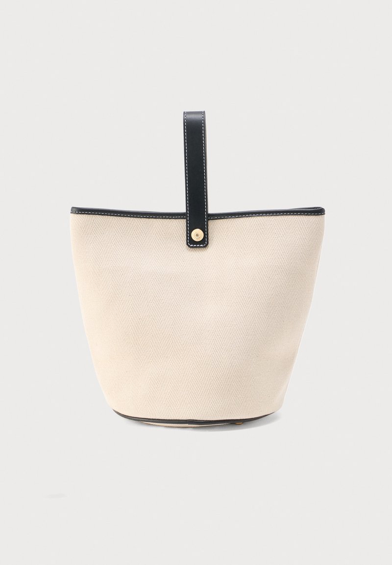 Τσάντα κουβάς από μπεζ ύφασμα με διακριτικό σχέδιο ζιγκ ζαγκ, μαύρο δερμάτινο περίγραμμα και μια μαύρη δερμάτινη λουρίδα με χρυσό κουμπί.