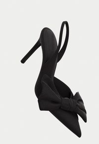 Zwarte hoge hak slingback schoen met spitse neus en grote stoffen strikdetail aan de voorkant.