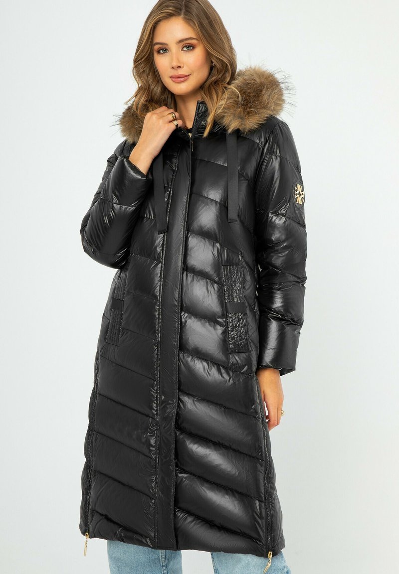 Schwarzer, gepolsterter langer Mantel mit glänzender Oberfläche. Verfügt über eine mit Fell gefütterte Kapuze, Reißverschlusstaschen und strukturierte Paneelakzente. Silberne Hardware-Details.