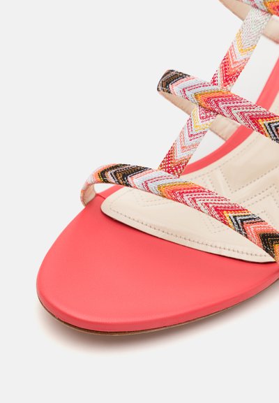 Korallfärgad platt sandal med flerfärgade vävda remmar som har ett chevronmönster. Slät syntetisk läderfotbädd och klassisk avsmalnande tåform.