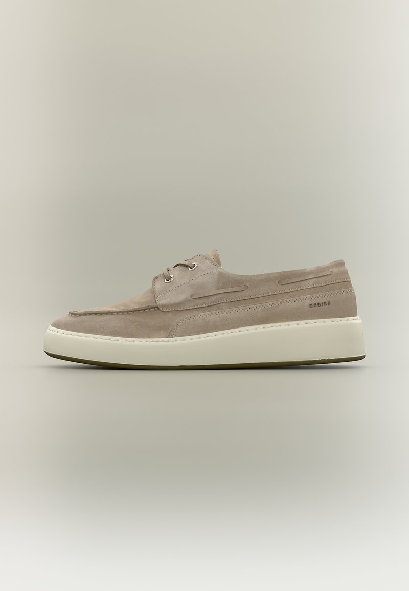 Μπεζ καφέ δερμάτινο παπούτσι casual με κορδόνια, λευκή χοντρή σόλα, ραμμένες λεπτομέρειες και διακριτικό κείμενο μάρκας στην πλευρά, εμφανιζόμενο σε πλαϊνή όψη.