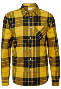 Żółto-czarna koszula w kratę z długim rękawem i kołnierzykiem zapinanym na guziki, z kieszenią na piersi i białymi guzikami. Teksturowana tkanina.