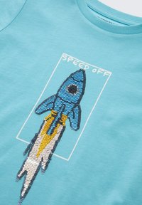 Lichtblauwe katoenen t-shirt met een raketontwerp in blauw, geel en zwart, met de tekst "SPEED OFF" erboven in het wit.