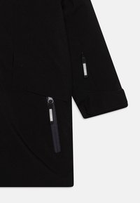 Schwarze Softshell-Jacke mit Reißverschlusstaschen, gefütterten Ärmeln und einem eleganten Design. Der Stoff hat eine glatte Textur und ist langlebig.