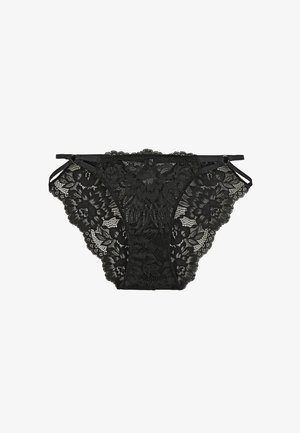 Sous-vêtements féminins en dentelle noire avec motifs floraux et fines bretelles latérales réglables sur fond blanc.