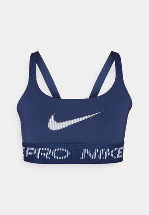 Navy blauwe sportbeha van soepel materiaal, met een witte Nike swoosh en een elastische band met de tekst "PRO NIKE" in het wit.