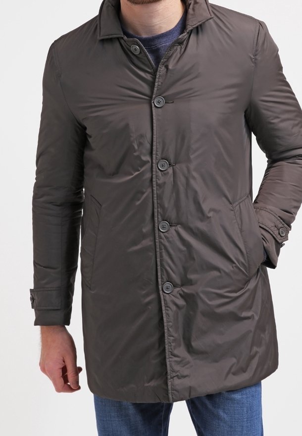 Tmavě hnědý, lehký, prošívaný kabát s límcem, šesti knoflíky a dvěma bočními kapsami. Má hladkou, lesklou texturu.