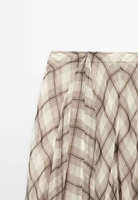 Brauner und beiger karierter Stoff mit durchscheinender Textur. Verfügt über Falten am oberen Rand und ein leichtes Design, das sich gut zum Schichten eignet.