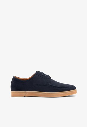 Chaussures bleu suede à lacets avec une texture lisse, semelle en caoutchouc, accents contrastants en tan et un design à bout rond.