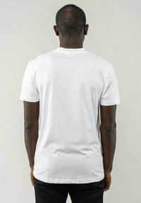 Witte T-shirt met korte mouwen van katoen, met een ronde hals en een eenvoudig ontwerp, van achteraf weergegeven zonder zichtbare patronen of details.