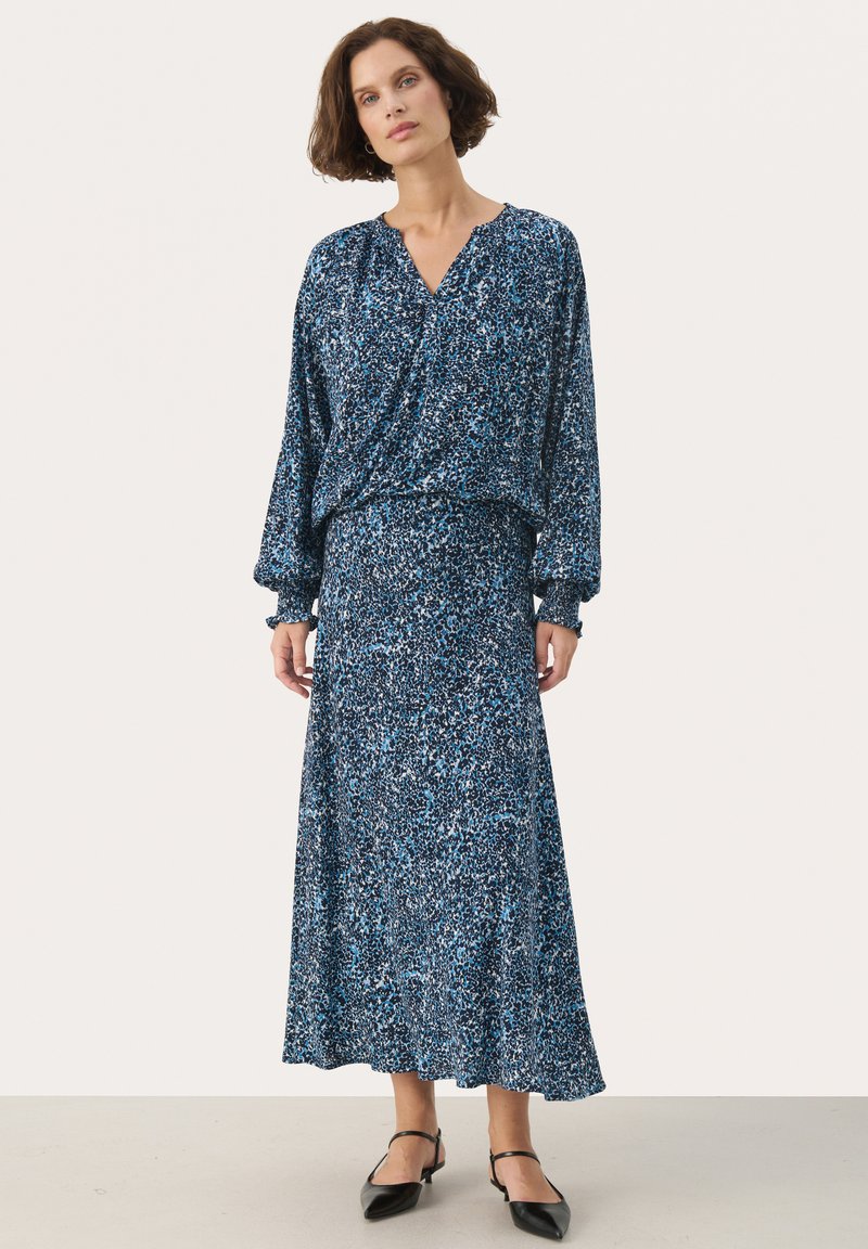 Blau gemustertes Kleid mit langen Ärmeln und lockerer Passform, mit V-Ausschnitt und passendem langen Rock. Leichter Stoff mit einem fließenden Textur.