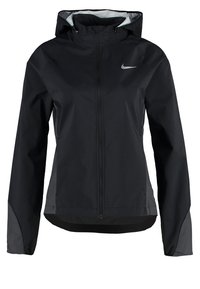 Veste coupe-vent à capuche noire Nike avec fermeture éclair devant, manches longues et logo Swoosh réfléchissant sur la poitrine.