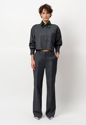 Grijze cropped shirt met een pailletten kraag, gecombineerd met grijze op maat gemaakte broek; zachte stof met een lichte textuur en rechte pijpen.