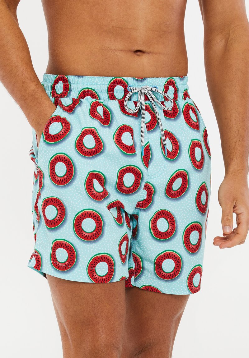 Costume da bagno con una base azzurro chiaro, caratterizzato da un motivo di angurie rosse e verdi. Vita elasticizzata con cordino e tasche laterali.