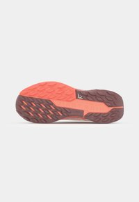 Semelle de chaussure de trail Nike en marron et orange vif, dotée d'une surface texturée avec un motif en zigzag pour une meilleure adhérence.