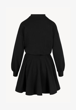 Zwarte jurk met lange mouwen, een getailleerde taille, geribbelde manchetten en een uitlopende rok, gezien van achteren tegen een witte achtergrond.