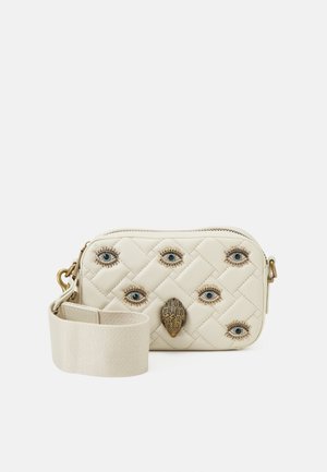 Kleine gesteepte crèmekleurige tas met zes decoratieve oogpatronen en een centraal metalen detail in de vorm van een hand, met een brede crèmekleurige schouderband.