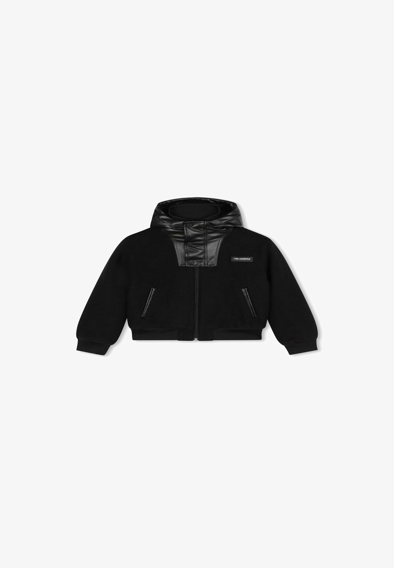 Veste noire avec fermeture éclair sur le devant, capuche rembourrée et accents en similicuir. Elle dispose de deux poches latérales zippées et de poignets côtelés.