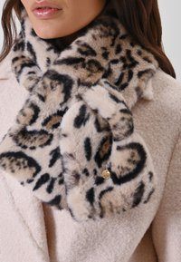 Écharpe en fausse fourrure à motif léopard avec une texture douce, une base beige et des accents noirs. Comprend un petit détail de tag en doré.