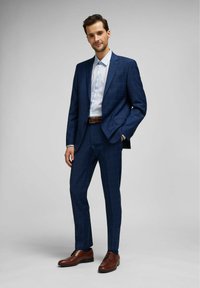 Navy blue plaid suit with slim fit, featuring a single-button blazer, paired with a light blue dress shirt and brown leather dress shoes.