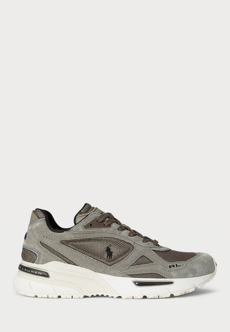 Gray suede and mesh sneaker with textured detailing, white midsole, and black accents, featuring laces and a logo on the side.