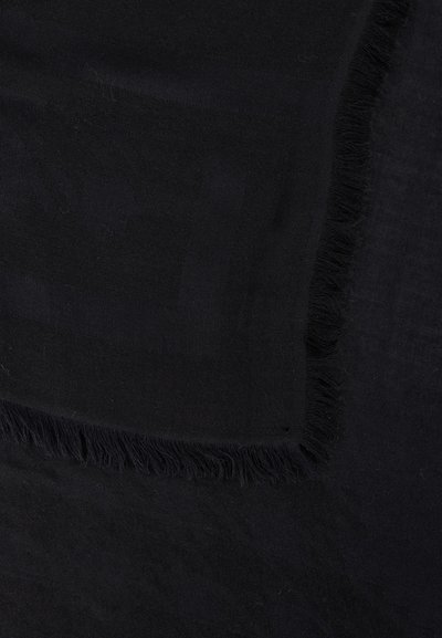 Tissu noir avec bords effilochés et un motif subtil visible dans le tissage sur une surface plate.