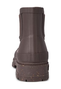 Botte en caoutchouc marron à la cheville avec un design texturé, talon renforcé et semelle robuste. Éclats notables sur la semelle et bord supérieur rigide.