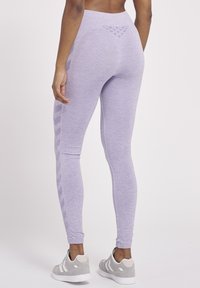 Paarse sportleggings hebben een gestructureerd ontwerp op de tailleband en subtiele zijpatronen, gemaakt van een zachte, rekbare stof.