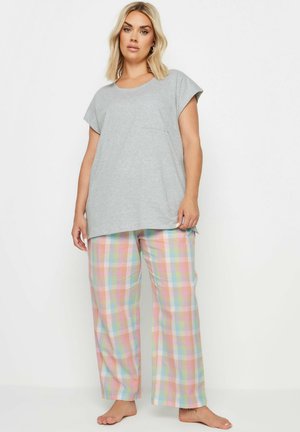 T-shirt gris à manches courtes avec une poche, associé à un pantalon de pyjama en plaid pastel avec des carreaux roses, bleus, verts et jaunes.