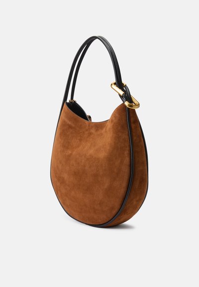 Sac à main en suede marron avec une silhouette courbée, des bordures en cuir noir et un détail en matériel doré sur la sangle.