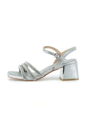 Sandal basso argentato con tacco alto, quattro cinturini decorativi, chiusura con fibbia e un tacco largo. Texture liscia con una finitura metallica.