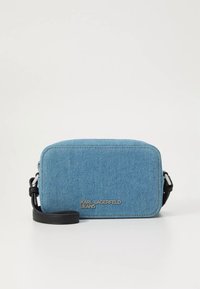 Modrá džínová kabelka přes rameno obdélníkového tvaru s černým koženým popruhem a stříbrným logem „KARL LAGERFELD JEANS“ na přední straně.