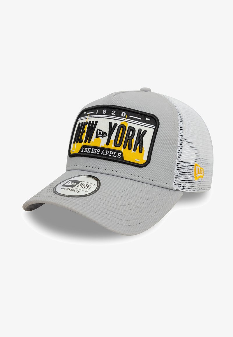 Casquette grise avec une visière courbée, dotée d'un patch brodé noir et jaune à l'avant portant l'inscription "NEW YORK THE BIG APPLE". Dos en mesh.