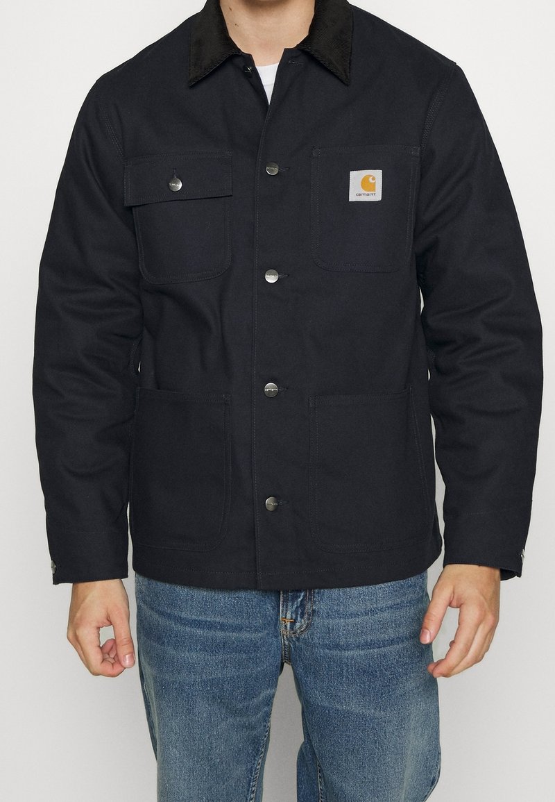 Dunkelblaue Jacke aus strapazierfähigem Material, mit einem Cordkragen, vier Fronttaschen und Druckknopfverschluss. Lässiges Design mit einer entspannten Passform.