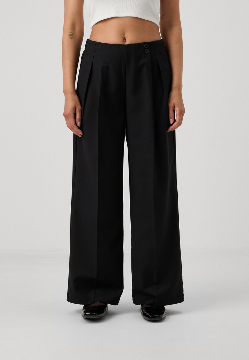 Black wide-leg trousers with a high waist, featuring pleats and two front buttons. Made from smooth fabric, they have a flowing silhouette.