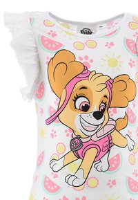 Camiseta blanca con un perro de dibujos animados vestido con un traje rosa, con mangas acampanadas y un patrón divertido de sandías y motivos del sol.