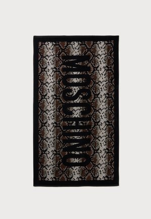 Serviette rectangulaire avec motif cuir de serpent marron, blanc et noir et grand texte vertical noir indiquant "MOSCHINO" au centre.