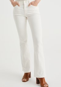 White, flared jeans with a high waist, made of denim. Features back pockets, five belt loops, and a front button closure.