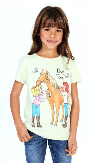 Ragazza che indossa una camicia chiara con un cartone animato di due bambini che accudiscono un cavallo e la scritta "Migliore squadra", abbinata a jeans blu.