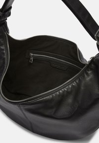 Borsa a tracolla nera in pelle con una texture liscia, dotata di chiusura con zip, una piccola tasca interna e una ampia apertura per un facile accesso.