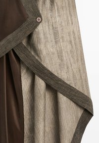 Panneau en tissu beige texturé avec une bordure marron foncé et des détails de boutons sur un tissu marron foncé lisse.