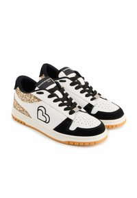 Baskets blanches et noires avec un accent doré pailleté sur le talon, comprenant un logo noir, une surface texturée et une semelle en caoutchouc.