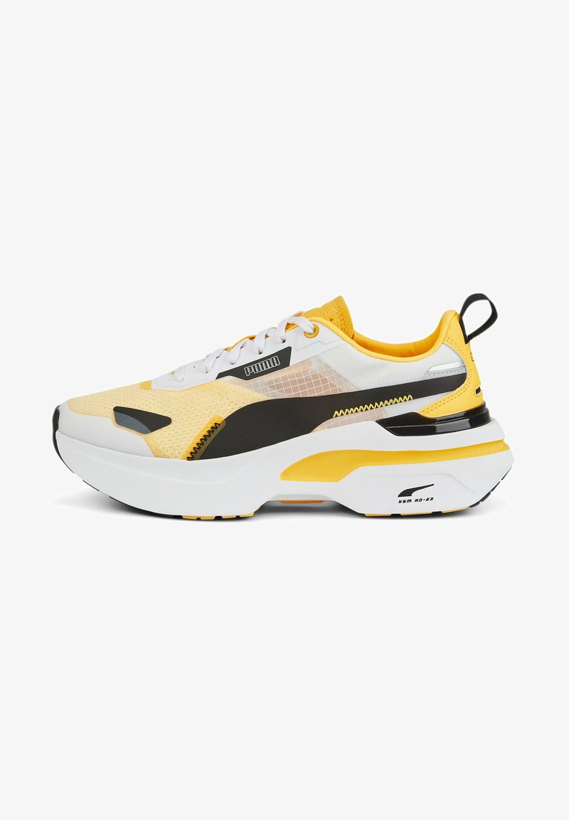 Sneaker Puma con tomaia in mesh giallo e bianco, dettagli neri, suola spessa bianca e design testurizzato.