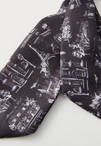 Schwarze Seidenkrawatte mit einem weißen Stadtbildmuster, das ikonische Gebäude und florale Akzente zeigt, mit einer strukturierten Oberfläche und schmalem Design.