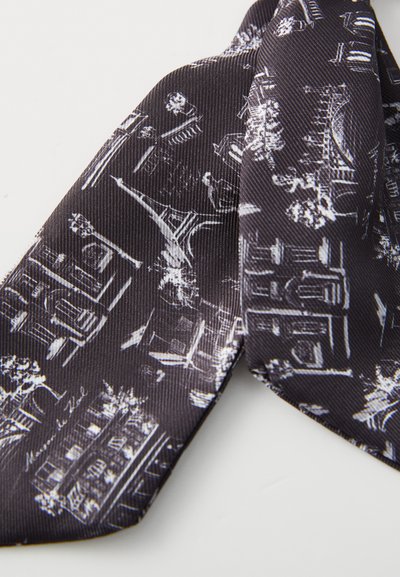 Cravate en soie noire ornée d'un motif de paysage urbain blanc avec des structures emblématiques et des accents floraux, mettant en avant une surface texturée et un design étroit.
