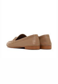Tan leather loafers with a sleek design, rounded toe, and small heel. Features a decorative metal accent on the vamp. Smooth texture.