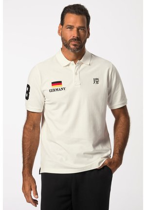 Hvid polo-shirt med korte ærmer, der har et sort nummer 8, teksten "TYSKLAND" og et lille tysk flag på venstre side. Blødt bomuldsstof.