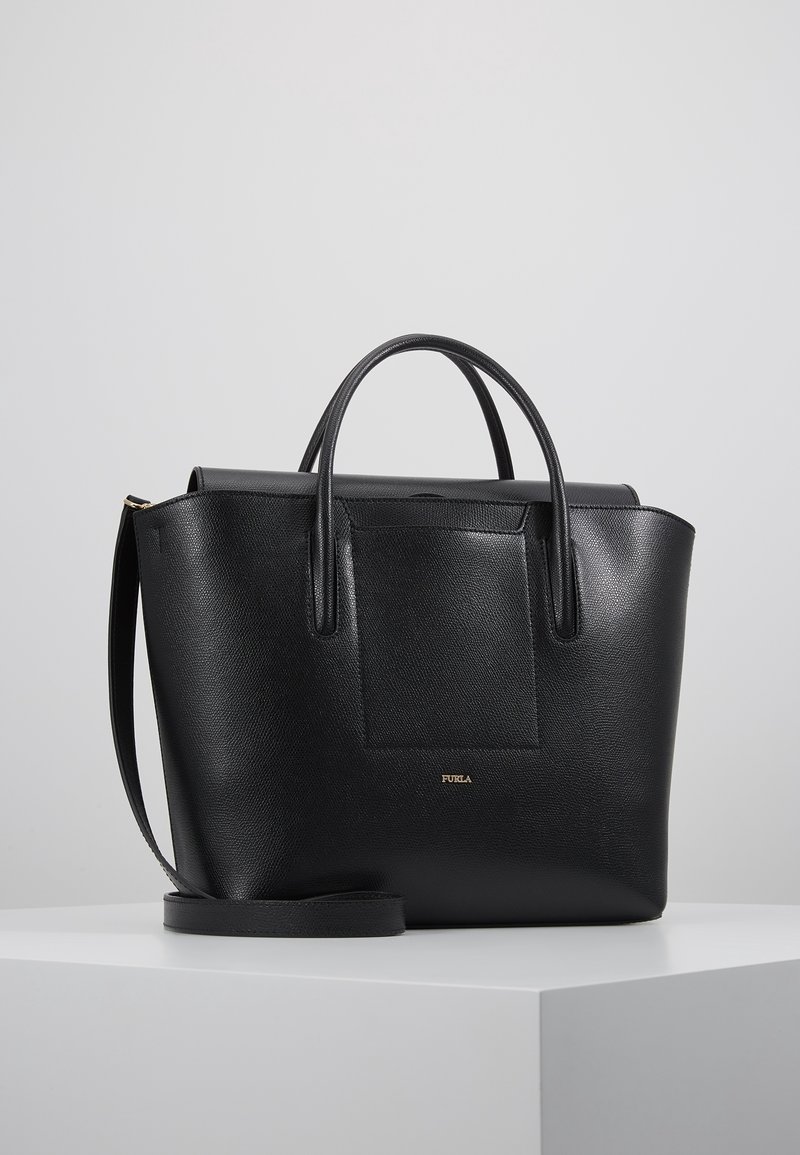 Svart läder tote väska med dubbla handtag och ett avtagbart axelband. Har en texturerad yta och en framficka med en gyllene emblem.