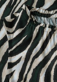 Kortärmad topp i bomullsblandning med ett grön- och beigemönstrat zebrastripe, med en rynkad halslinning och strukturerad yta.