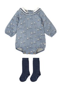 Mono de bebé de manga larga azul con patrón de barco de vela, cuello de marinero blanco, botones de madera y calcetas altas de rodilla de color azul marino.
